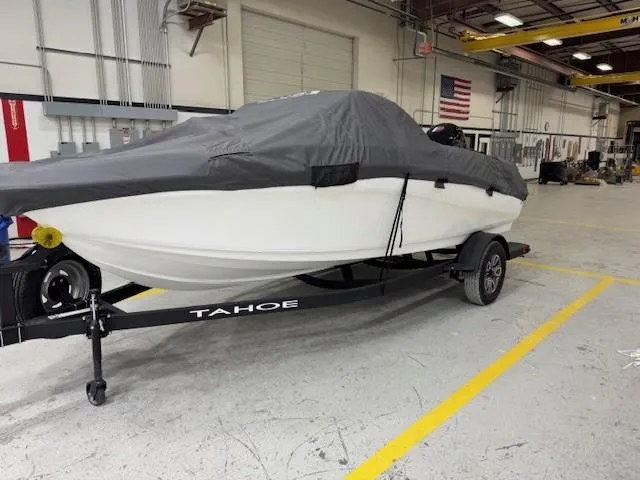 Slide: The Image of 2024 Tahoe 185 S boat covered on trailer in warehouse setting. - 10