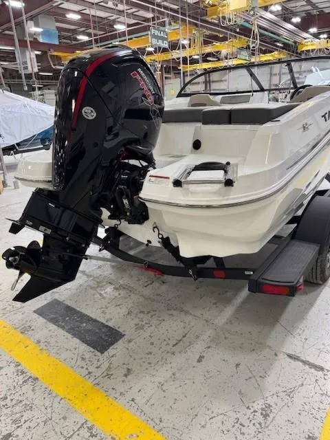 Slide: The Image of 2024 Tahoe 185 S boat with powerful outboard motor in a factory setting. - 3
