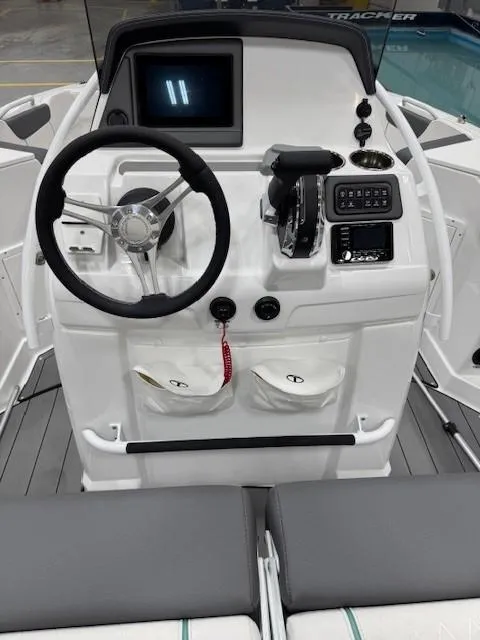 Slide: The Image of 2024 Tahoe 2150 CC boat dashboard with steering wheel and control panel. - 7