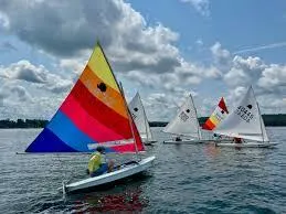 Slide: The Image of Sailboat on open water, SERO Innovation Sunfish 2026 model, blue and white sail. - 2