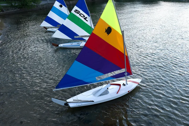 Slide: The Image of Colorful 2026 SERO Innovation Sunfish sailboats on a serene lake. - 5