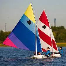 Slide: The Image of Two colorful SERO Innovation Sunfish sailboats on a lake, 2025 model. - 6