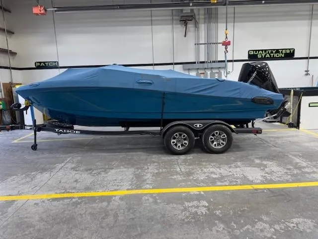 Slide: The Image of 2024 Tahoe 210 S Limited boat covered on trailer in a warehouse setting. - 13