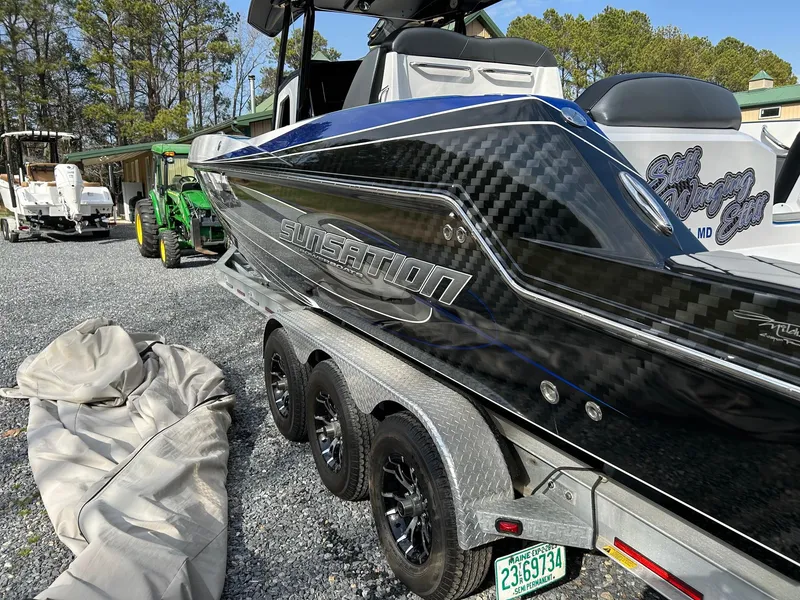 Slide: The Image of 2020 Sunsation 32 CCX boat on trailer, featuring sleek black and blue design. - 3