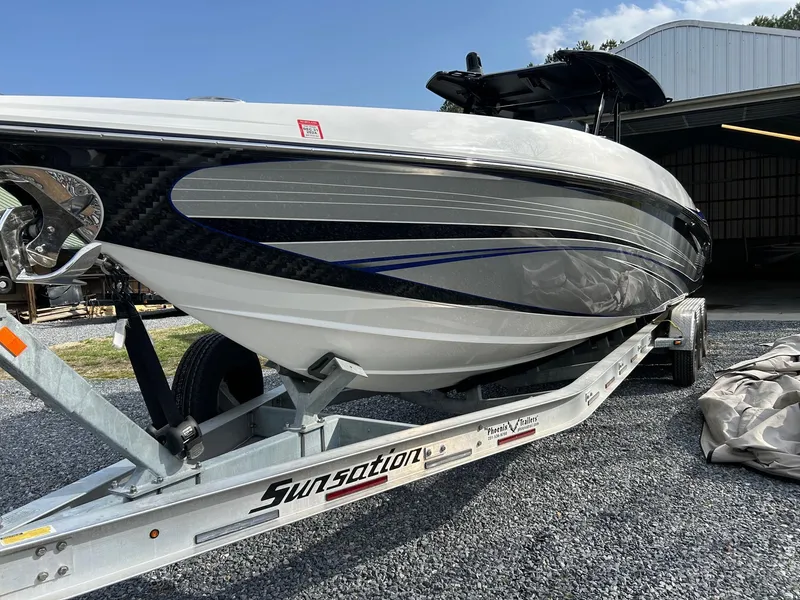 Slide: The Image of 2020 Sunsation 32 CCX boat on trailer, sleek design, parked outdoors. - 6