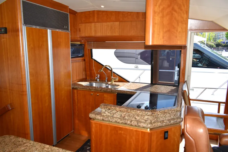 Slide: The Image of Luxurious kitchen interior of 2001 West Bay 58 RPH yacht with wood cabinetry and granite countertops. - 21