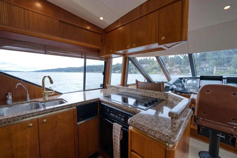 Slide: The Image of Luxurious 2001 West Bay 58 RPH yacht interior with modern kitchen and scenic water view. - 22