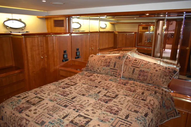 Slide: The Image of Luxurious bedroom interior of 2001 West Bay 58 RPH yacht with wood paneling and patterned bedding. - 35