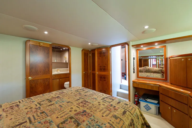 Slide: The Image of Luxurious bedroom interior of 2001 West Bay 58 RPH yacht with wood cabinetry and patterned bedding. - 36
