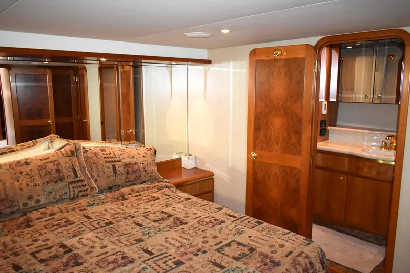 Slide: The Image of Luxurious bedroom interior of 2001 West Bay 58 RPH yacht with wood accents and ensuite bathroom. - 38