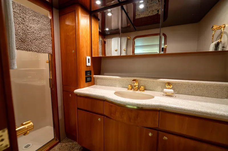 Slide: The Image of Luxurious bathroom in 2001 West Bay 58 RPH yacht with wood cabinetry and gold fixtures. - 39