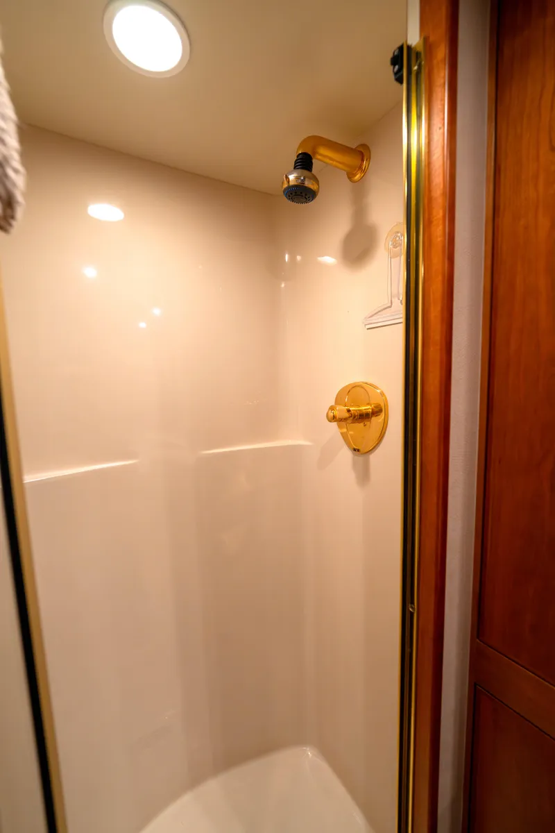 Slide: The Image of Shower area in 2001 West Bay 58 RPH yacht with gold fixtures and wooden accents. - 41
