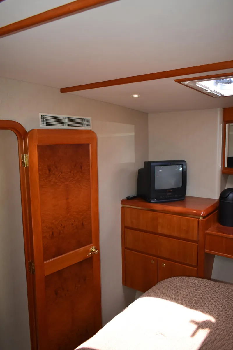 Slide: The Image of 2001 West Bay 58 RPH yacht interior with wood cabinetry and compact TV. - 50