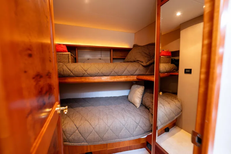 Slide: The Image of Bunk beds in 2001 West Bay 58 RPH yacht cabin with cozy bedding and warm lighting. - 51