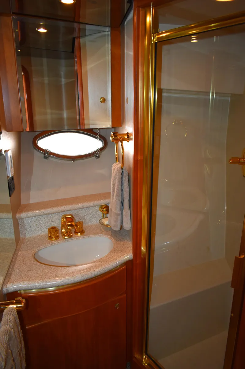 Slide: The Image of Luxurious bathroom in 2001 West Bay 58 RPH yacht with gold fixtures and glass shower. - 54