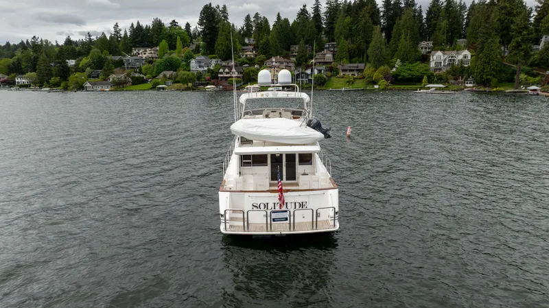 Slide: The Image of 2001 West Bay 58 RPH yacht on a scenic lake with forested shoreline. - 84