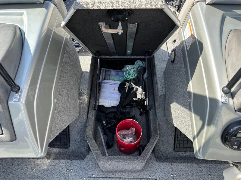 Slide: The Image of 2018 Tracker Targa V-19 WT boat storage compartment with gear and red bucket. - 28