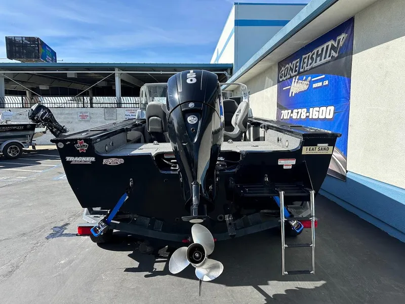 Slide: The Image of 2018 Tracker Targa V-19 WT boat with outboard motor, parked near a building. - 8