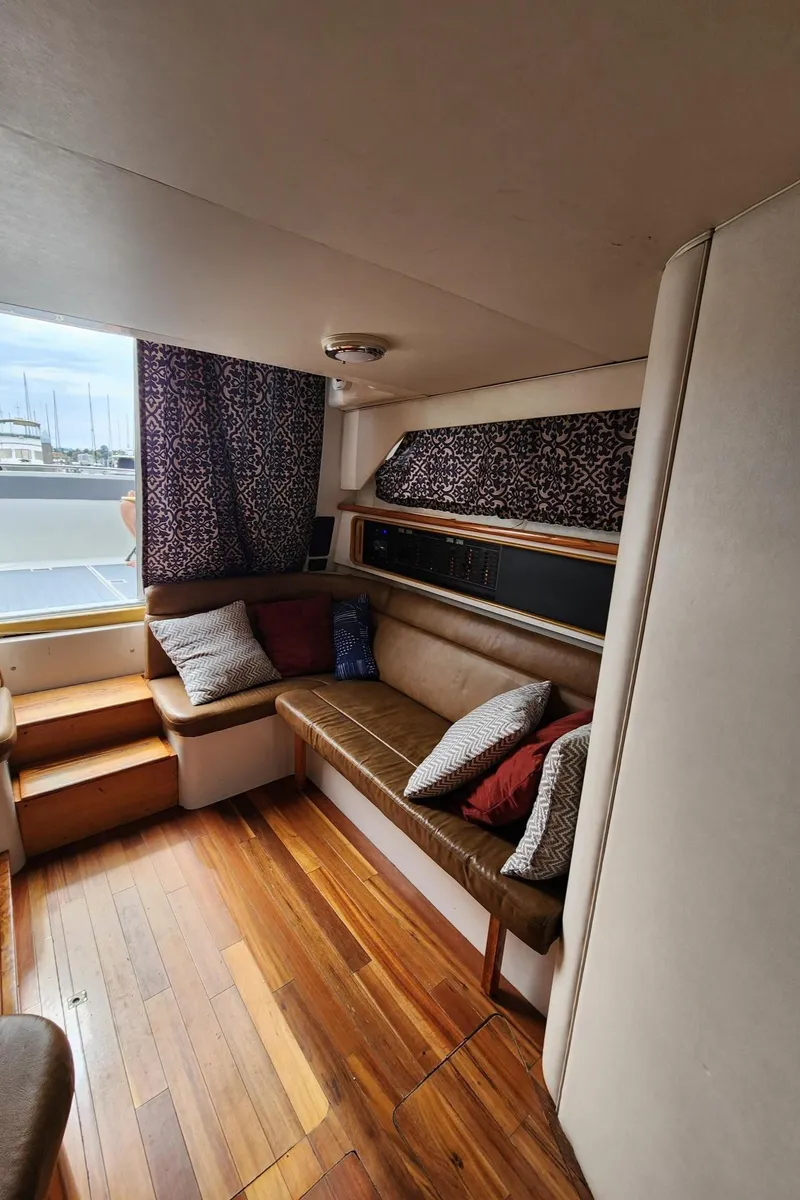 Slide: The Image of Interior of 1991 Wellcraft Triumph 34 boat with wooden flooring and cushioned seating. - 10
