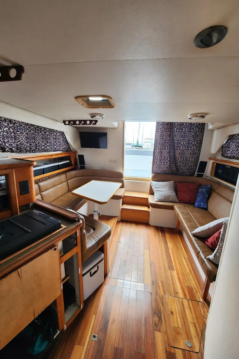 Slide: The Image of Interior of 1991 Wellcraft Triumph 34 boat with wood flooring and cozy seating area. - 11