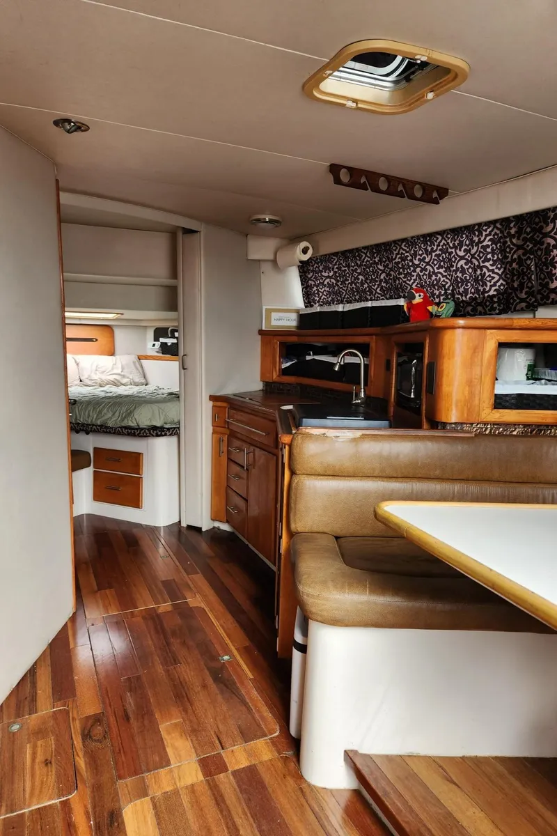 Slide: The Image of Interior of 1991 Wellcraft Triumph 34 boat with wood flooring and cozy dining area. - 12