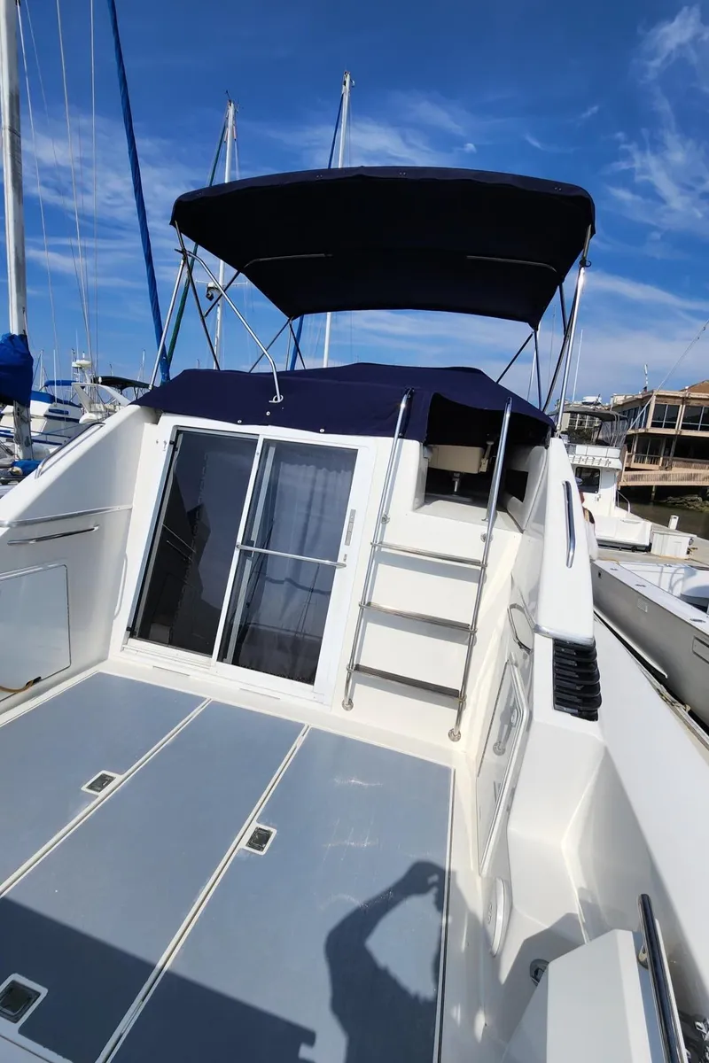 Slide: The Image of 1991 Wellcraft Triumph 34 boat with canopy, docked under clear blue sky. - 19