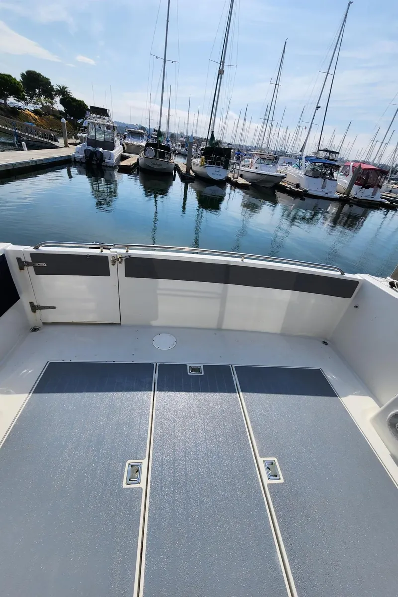 Slide: The Image of 1991 Wellcraft Triumph 34 boat deck at marina with docked sailboats. - 20