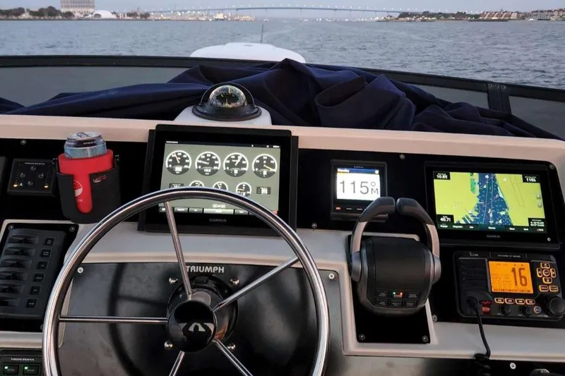 Slide: The Image of 1991 Wellcraft Triumph 34 boat dashboard with navigation instruments and steering wheel. - 4