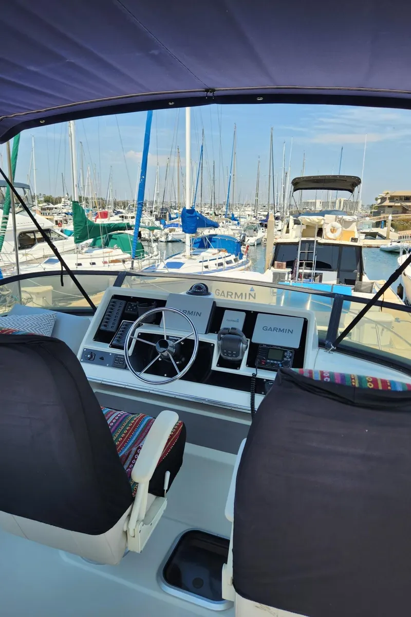 Slide: The Image of 1991 Wellcraft Triumph 34 boat cockpit with marina view, featuring steering wheel and navigation equipment. - 5