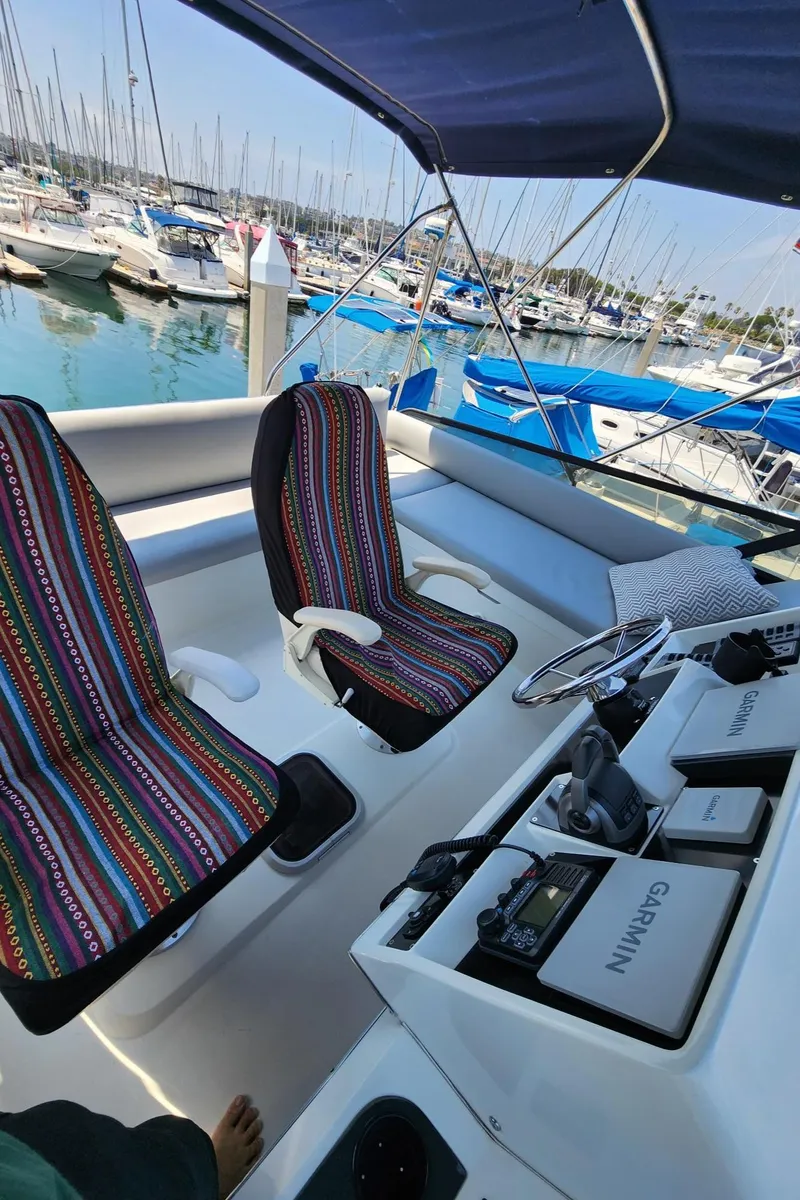 Slide: The Image of 1991 Wellcraft Triumph 34 boat interior with striped seats and marina view. - 6