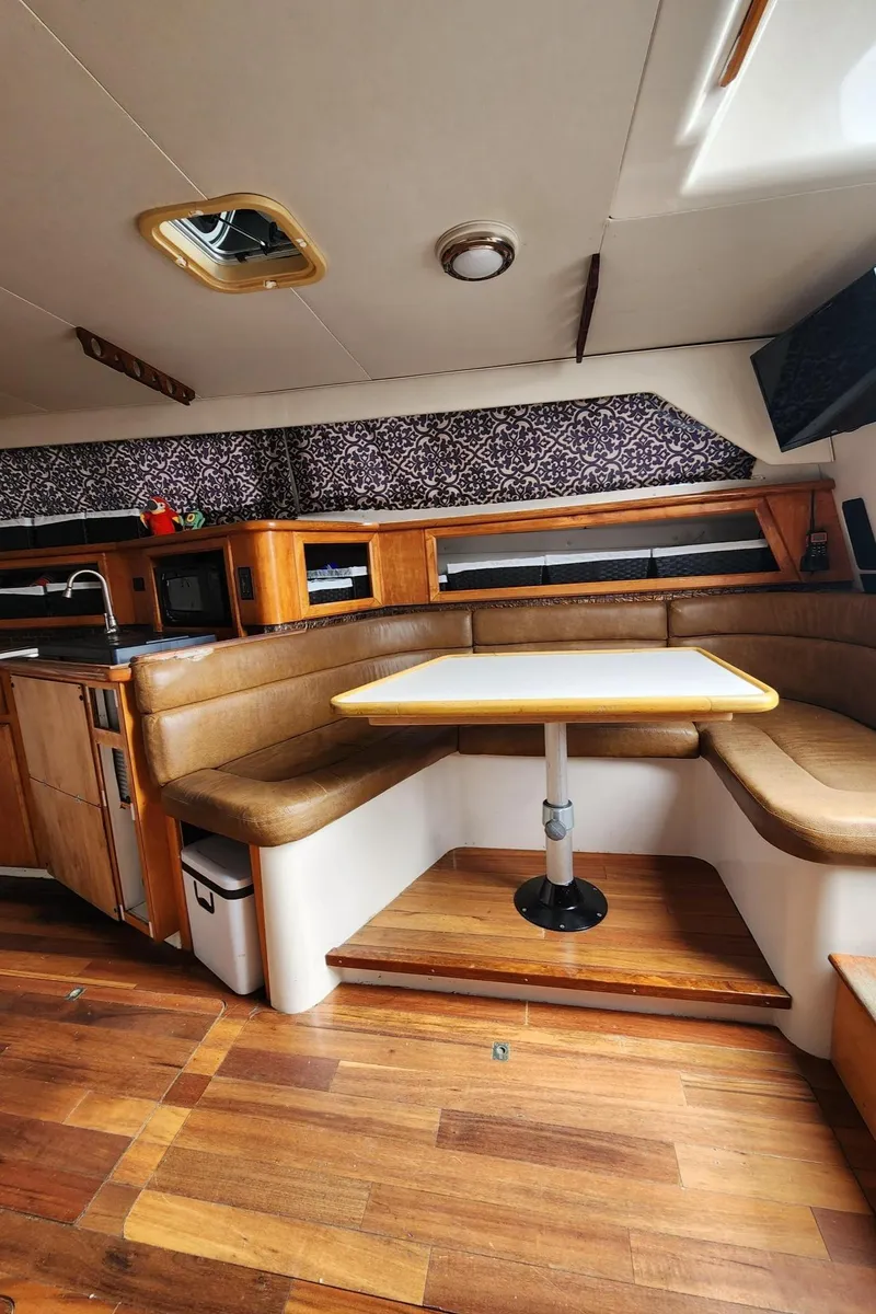 Slide: The Image of Interior of 1991 Wellcraft Triumph 34 boat with wood flooring and cozy dining area. - 7