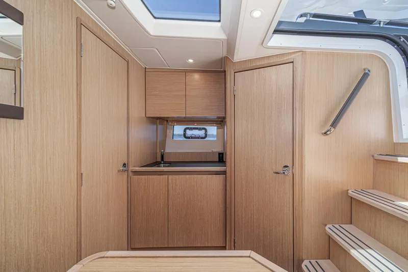 Slide: The Image of Interior of 2023 Bavaria SR36 yacht with modern wood finish and compact kitchen area. - 45