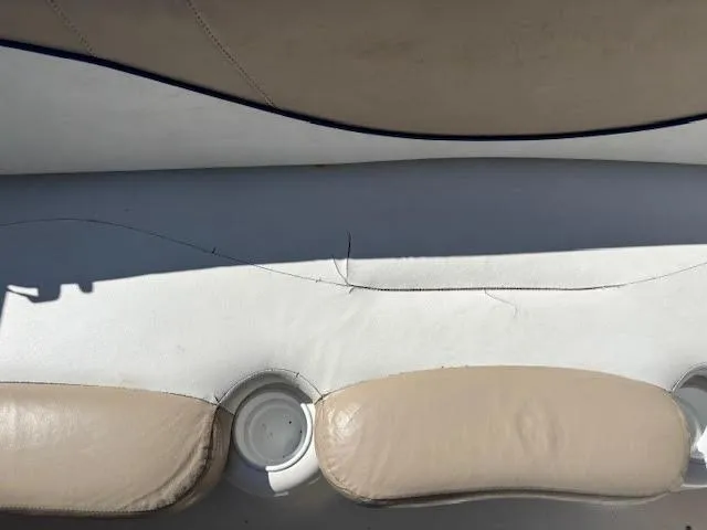 Slide: The Image of 2005 Glastron MX 175 boat seat with visible cracks and cup holder. - 12