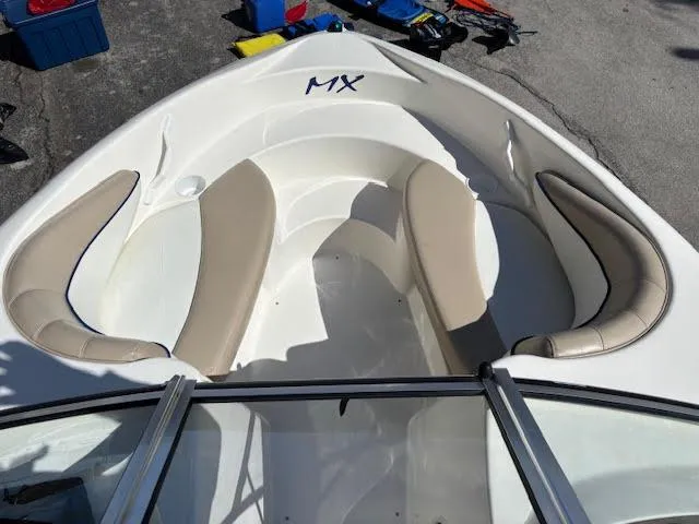 Slide: The Image of 2005 Glastron MX 175 boat interior with beige seating and open bow design. - 19