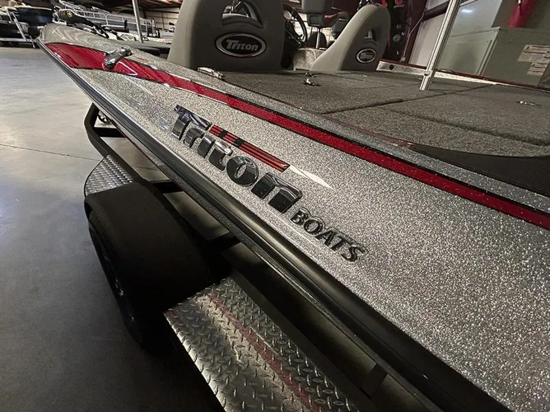 Slide: The Image of 2023 Triton 179 TrX boat with metallic finish and logo in showroom. - 1