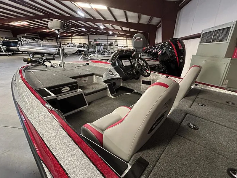 Slide: The Image of 2023 Triton 179 TrX bass boat interior with seating and control panel in a showroom. - 3