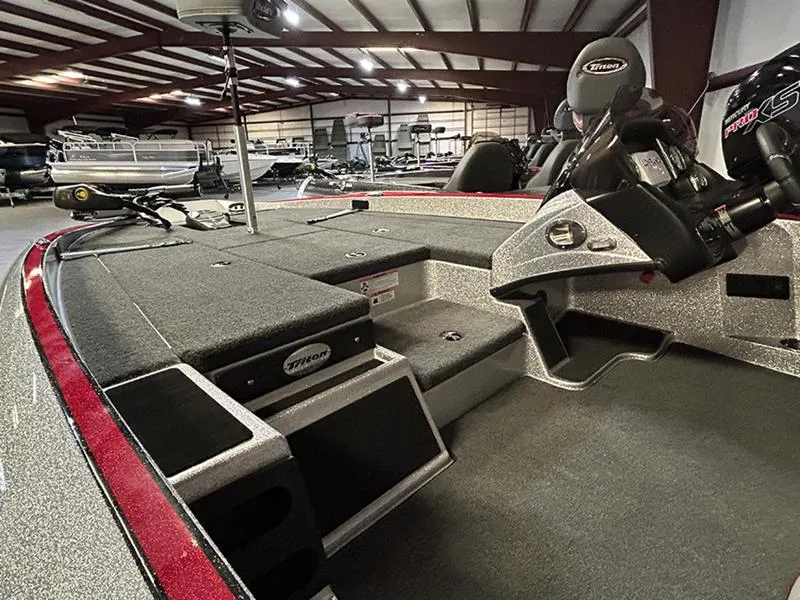Slide: The Image of 2023 Triton 179 TrX boat interior with spacious deck and seating in a showroom. - 4