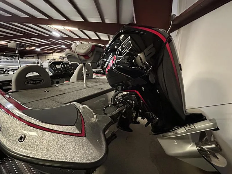 Slide: The Image of 2023 Triton 179 TrX boat with powerful outboard motor in showroom. - 5