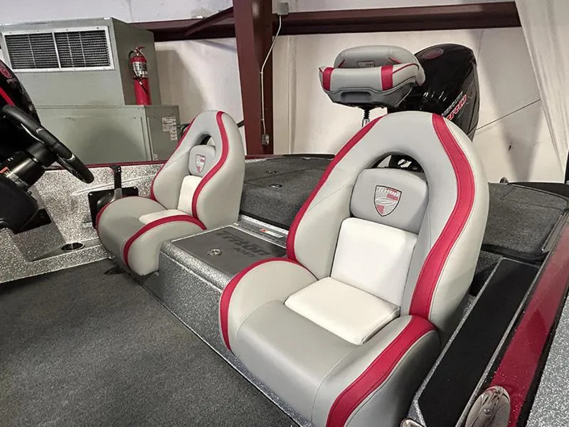 Slide: The Image of 2023 Triton 179 TrX boat interior with gray and red seats, steering wheel, and motor. - 8