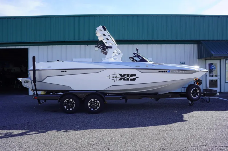 Slide: The Image of 2019 Axis A22 boat on trailer, parked outside a building. - 1