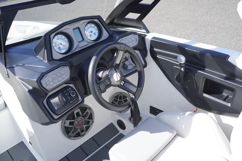 Slide: The Image of 2019 Axis A22 boat dashboard with steering wheel, gauges, and controls. - 19