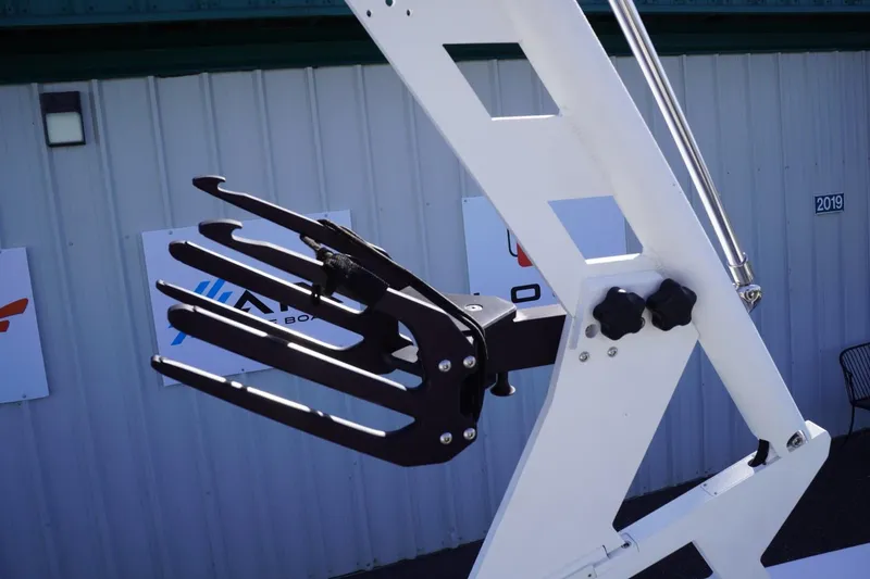 Slide: The Image of 2019 Axis A22 boat tower with wakeboard rack against a metal building backdrop. - 43
