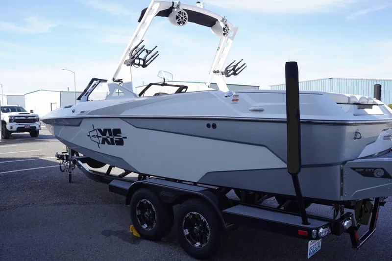 Slide: The Image of 2019 Axis A22 boat on trailer, parked outdoors, featuring sleek design and modern wakeboard tower. - 7