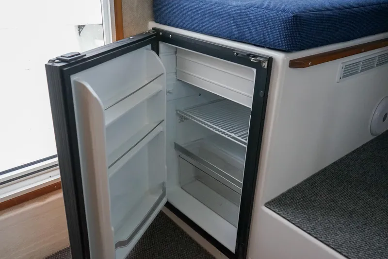 Slide: The Image of Open refrigerator inside 2025 Sea Sport 26' Aleutian boat, showcasing interior storage space. - 14