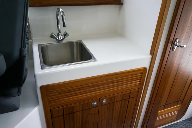 Slide: The Image of Compact kitchenette with sink in 2025 Sea Sport 26' Aleutian boat interior. - 15