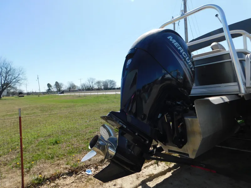 Slide: The Image of 2017 Sun Tracker Fishin' Barge 22 XP3 with Mercury outboard motor, parked on grass. - 7
