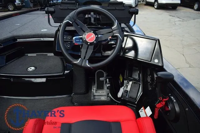 Slide: The Image of 2024 Ikon Boats LX21 cockpit with steering wheel, control panel, and red seating. - 12