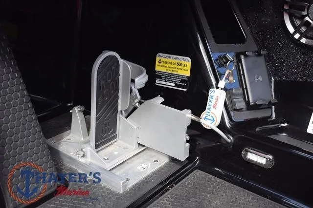 Slide: The Image of 2024 Ikon Boats LX21 interior with foot pedal and control panel, featuring safety capacity label. - 14