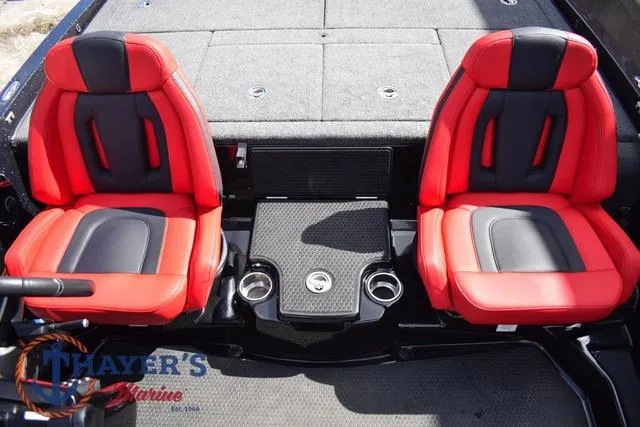 Slide: The Image of 2024 Ikon Boats LX21 interior with red and black seats, cup holders, and Thayer's Marine logo. - 17