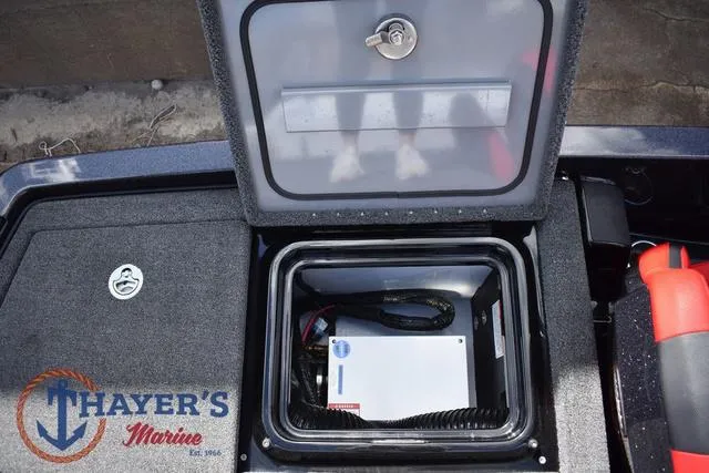 Slide: The Image of 2024 Ikon Boats LX21 storage compartment with secure lock and Thayer's Marine branding. - 29